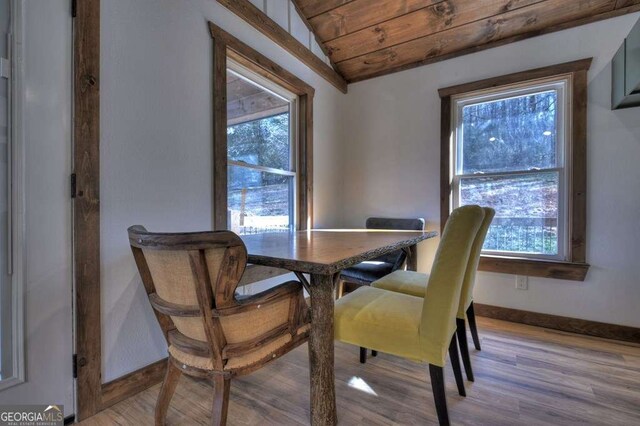 dining area featuring light wood-type flooring, a wealth of natural light, vaulted ceiling, and wooden ceiling