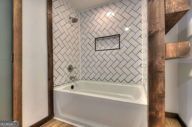 bathroom featuring tiled shower / bath combo and hardwood / wood-style floors