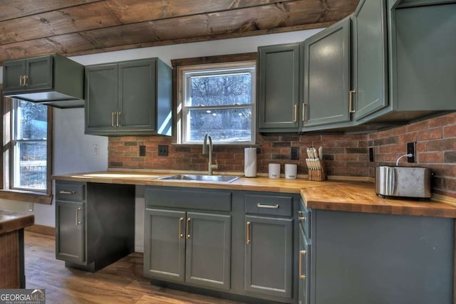 kitchen featuring dark wood-type flooring, wood counters, sink, tasteful backsplash, and green cabinetry