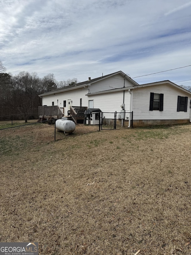 view of side of property featuring a yard and a deck