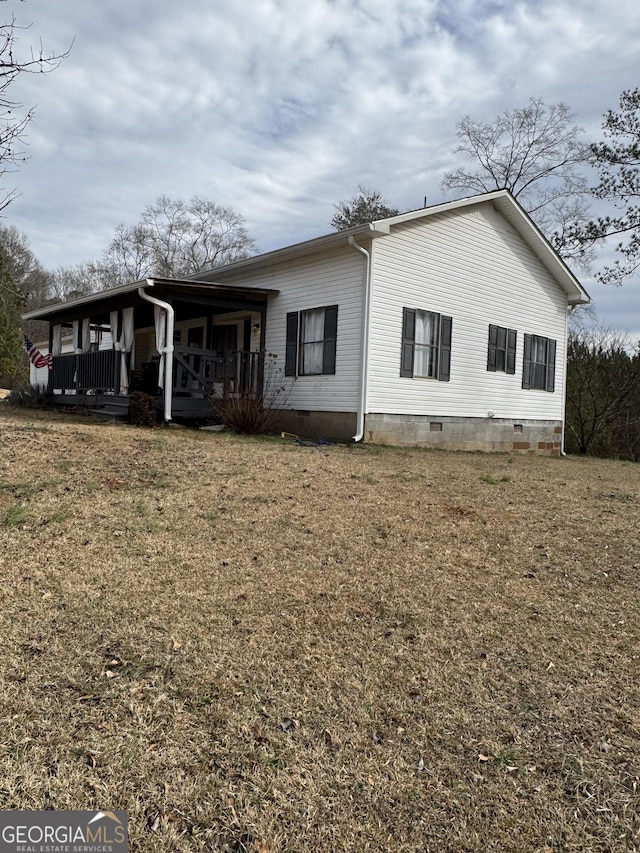 back of house with a porch and a yard