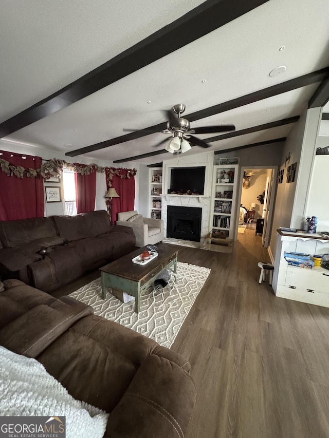 living room with beamed ceiling, ceiling fan, dark hardwood / wood-style flooring, and built in shelves