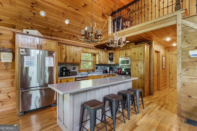 kitchen featuring wood ceiling, appliances with stainless steel finishes, a center island, tasteful backsplash, and decorative light fixtures