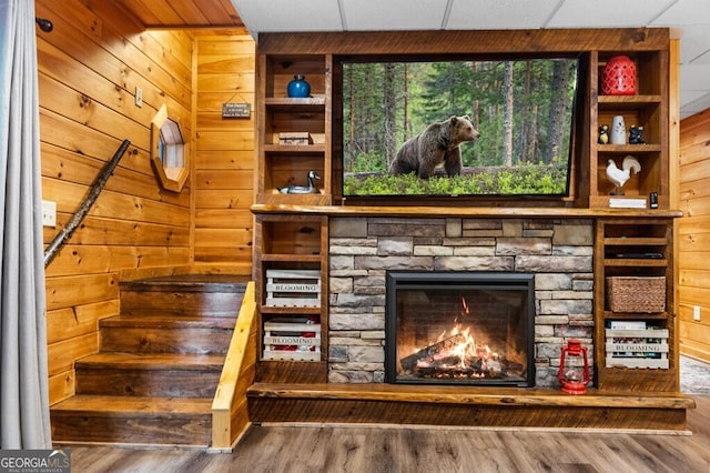 room details with hardwood / wood-style flooring, a fireplace, and wood walls