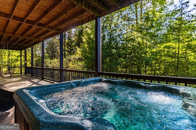 view of swimming pool with a hot tub and a deck