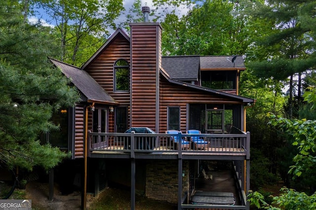 rear view of house featuring a wooden deck