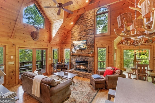 living room with wooden ceiling, high vaulted ceiling, light hardwood / wood-style flooring, and wood walls