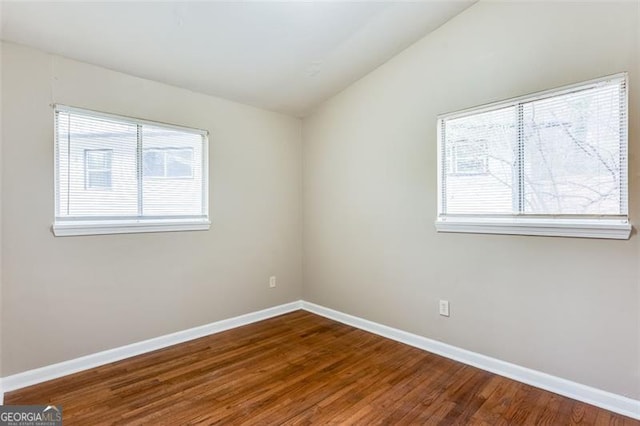 empty room featuring lofted ceiling and hardwood / wood-style flooring