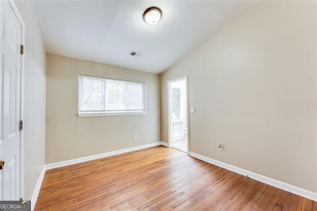 unfurnished bedroom with lofted ceiling and light hardwood / wood-style floors