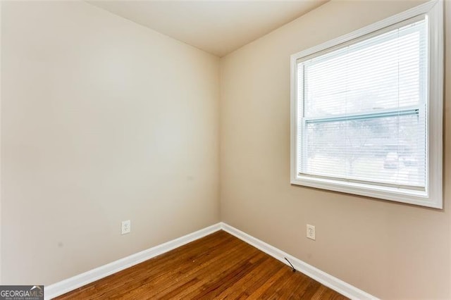 unfurnished room with dark hardwood / wood-style flooring and a wealth of natural light