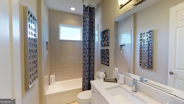 full bathroom featuring vanity, shower / bath combo with shower curtain, and toilet