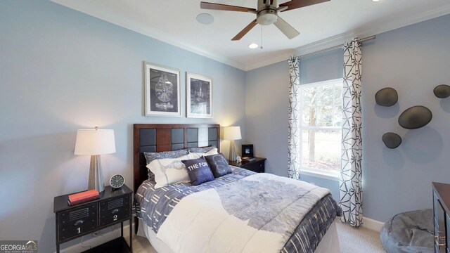 bedroom with a crib, crown molding, light carpet, and ceiling fan