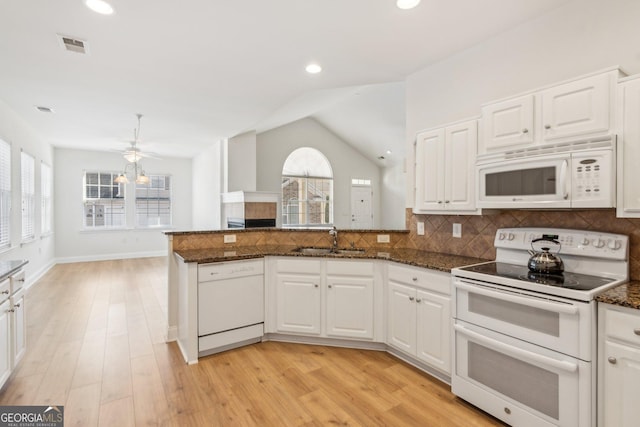 kitchen featuring white appliances, dark stone countertops, sink, and white cabinets