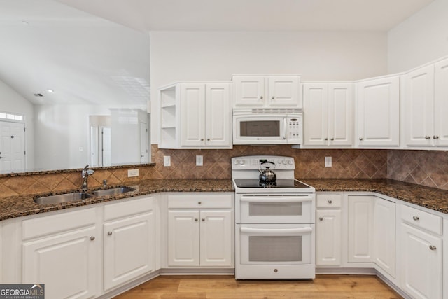 kitchen featuring white cabinetry, sink, dark stone countertops, and white appliances