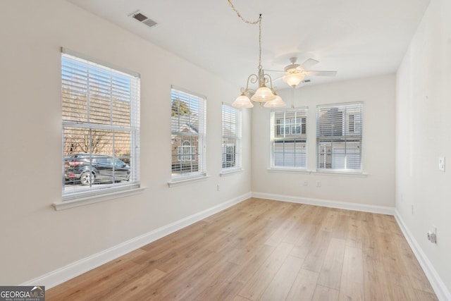 unfurnished dining area featuring light hardwood / wood-style flooring and a notable chandelier