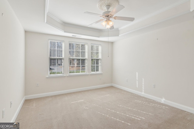 spare room with crown molding, light colored carpet, a raised ceiling, and ceiling fan