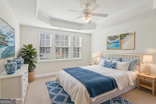 carpeted bedroom featuring crown molding, a raised ceiling, and ceiling fan