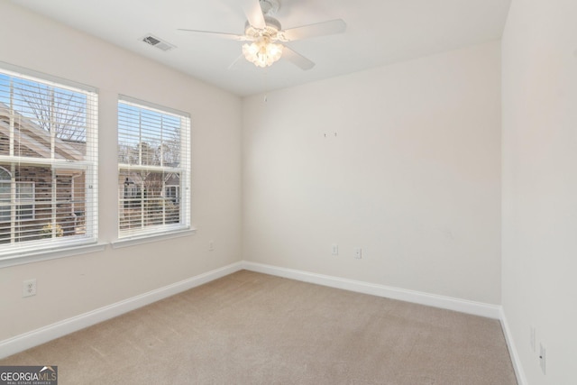 carpeted spare room featuring ceiling fan