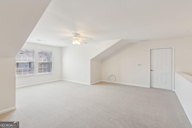 bonus room featuring light carpet and ceiling fan