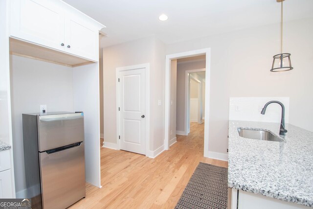 69 Oakhurst Trl, Sharpsburg, GA 30277 - kitchen featuring freestanding refrigerator, white cabinetry, light wood-type flooring, light stone counters, and recessed lighting