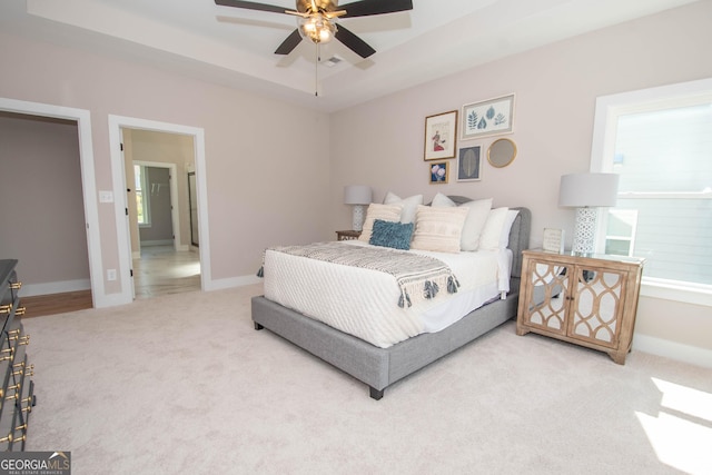 69 Oakhurst Trl, Sharpsburg, GA 30277 - bedroom with light colored carpet, a tray ceiling, a ceiling fan, and multiple windows