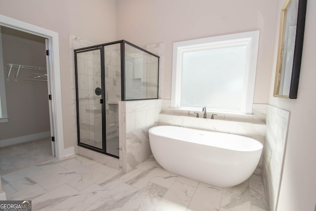 69 Oakhurst Trl, Sharpsburg, GA 30277 - full bath featuring a soaking tub, a stall shower, a spacious closet, marble finish flooring, and tile walls