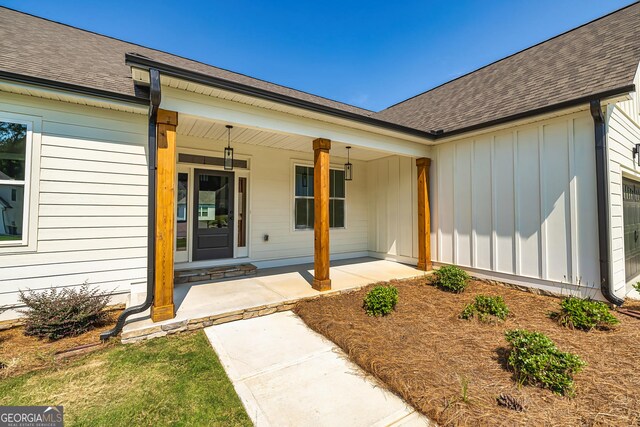 69 Oakhurst Trl, Sharpsburg, GA 30277 - view of exterior entry featuring board and batten siding, covered porch, and a shingled roof