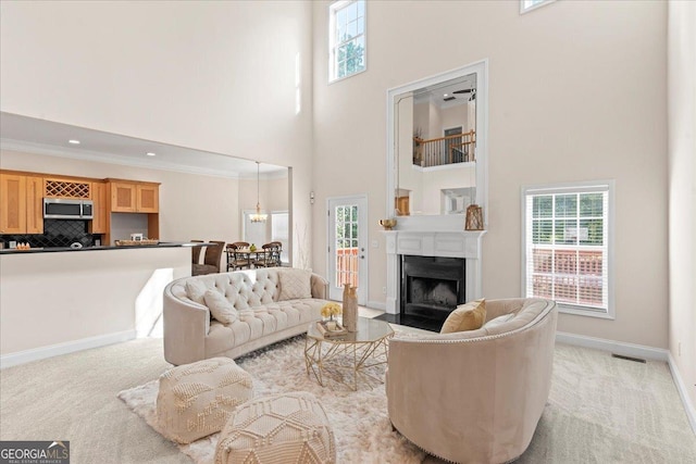 carpeted living room with crown molding and a towering ceiling