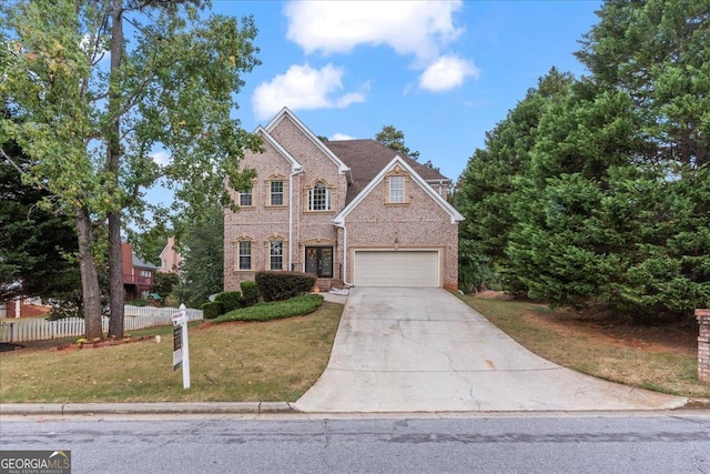 view of property with a garage and a front lawn