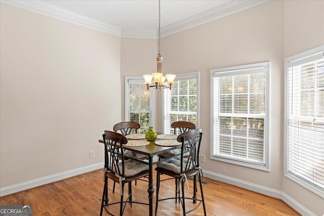 dining space featuring a notable chandelier, crown molding, and light wood-type flooring