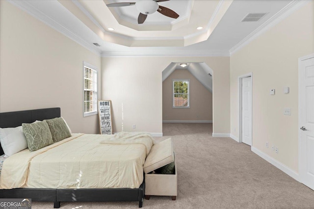 carpeted bedroom with a raised ceiling, crown molding, and ceiling fan