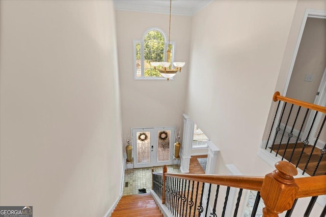 stairway with hardwood / wood-style floors, a wealth of natural light, and a chandelier