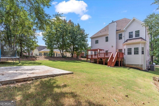 view of yard with a trampoline, a wooden deck, central AC, and a patio