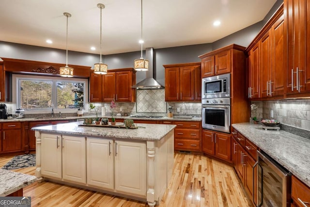 kitchen with stainless steel appliances, a kitchen island, wine cooler, and light stone counters