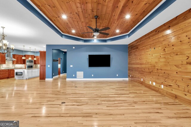1580 Loving Rd, Morganton, GA 30560 - unfurnished living room with wooden walls, light wood-style floors, ceiling fan with notable chandelier, visible vents, and wood ceiling