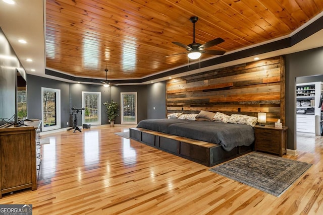 bedroom featuring wooden ceiling, ceiling fan, and wood walls