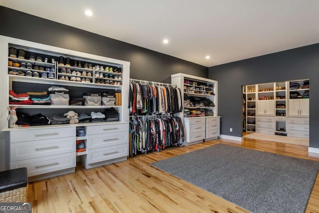 walk in closet with light hardwood / wood-style floors