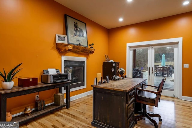 home office with light hardwood / wood-style flooring