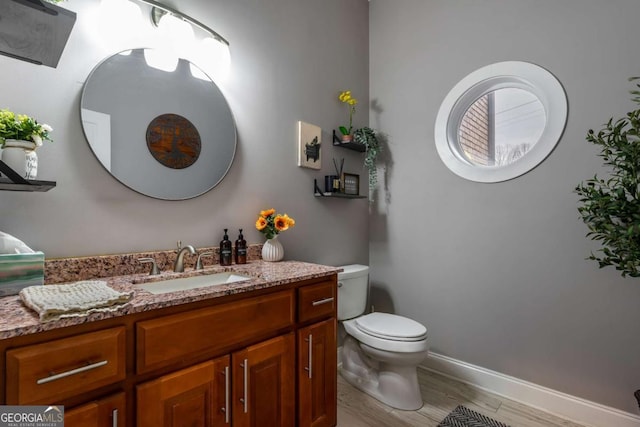 bathroom featuring hardwood / wood-style flooring, vanity, and toilet