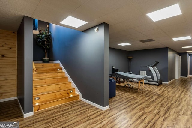 stairway featuring hardwood / wood-style floors and a drop ceiling