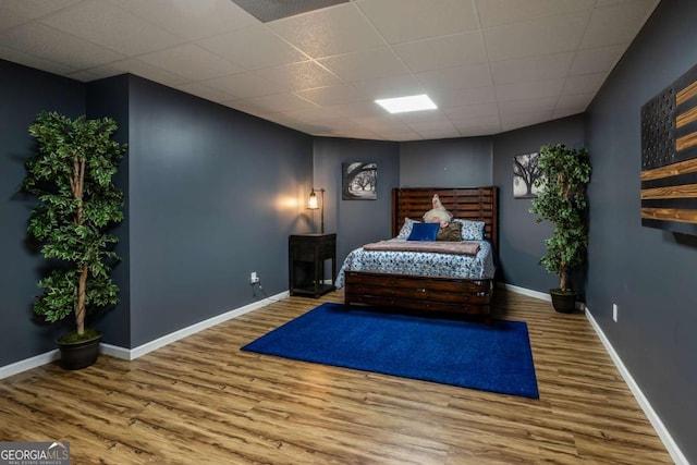 bedroom featuring hardwood / wood-style floors and a drop ceiling