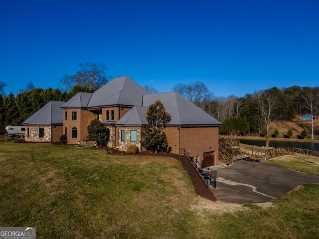 rear view of house featuring a yard and a garage