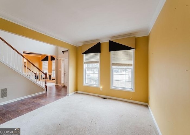 spare room featuring ornamental molding and carpet flooring