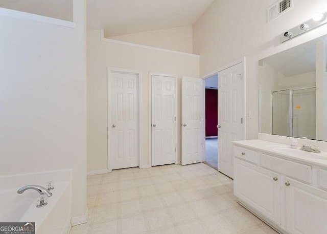 bathroom with vanity, lofted ceiling, and shower with separate bathtub