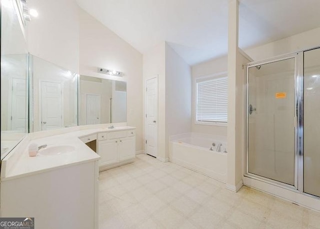 bathroom with vanity, independent shower and bath, and vaulted ceiling