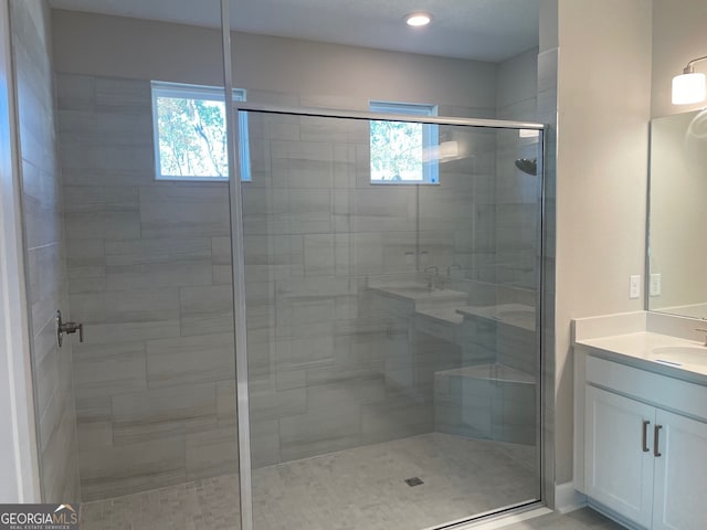 bathroom with a shower with door and vanity