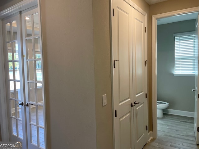 hall featuring light hardwood / wood-style flooring and french doors