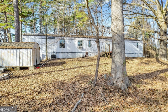 rear view of house with a storage unit