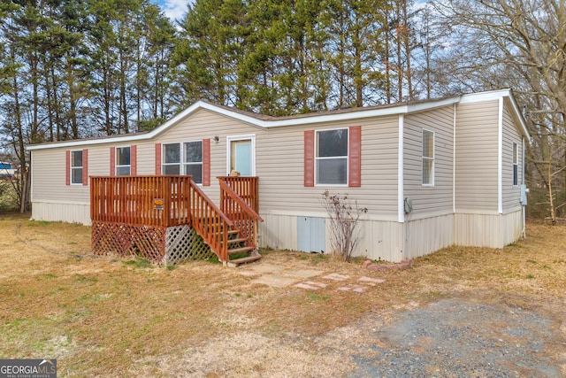 manufactured / mobile home with a wooden deck and a front yard