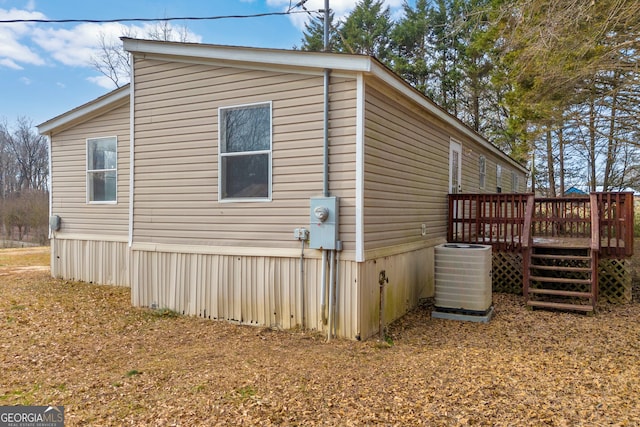 view of side of property featuring a wooden deck and central AC unit